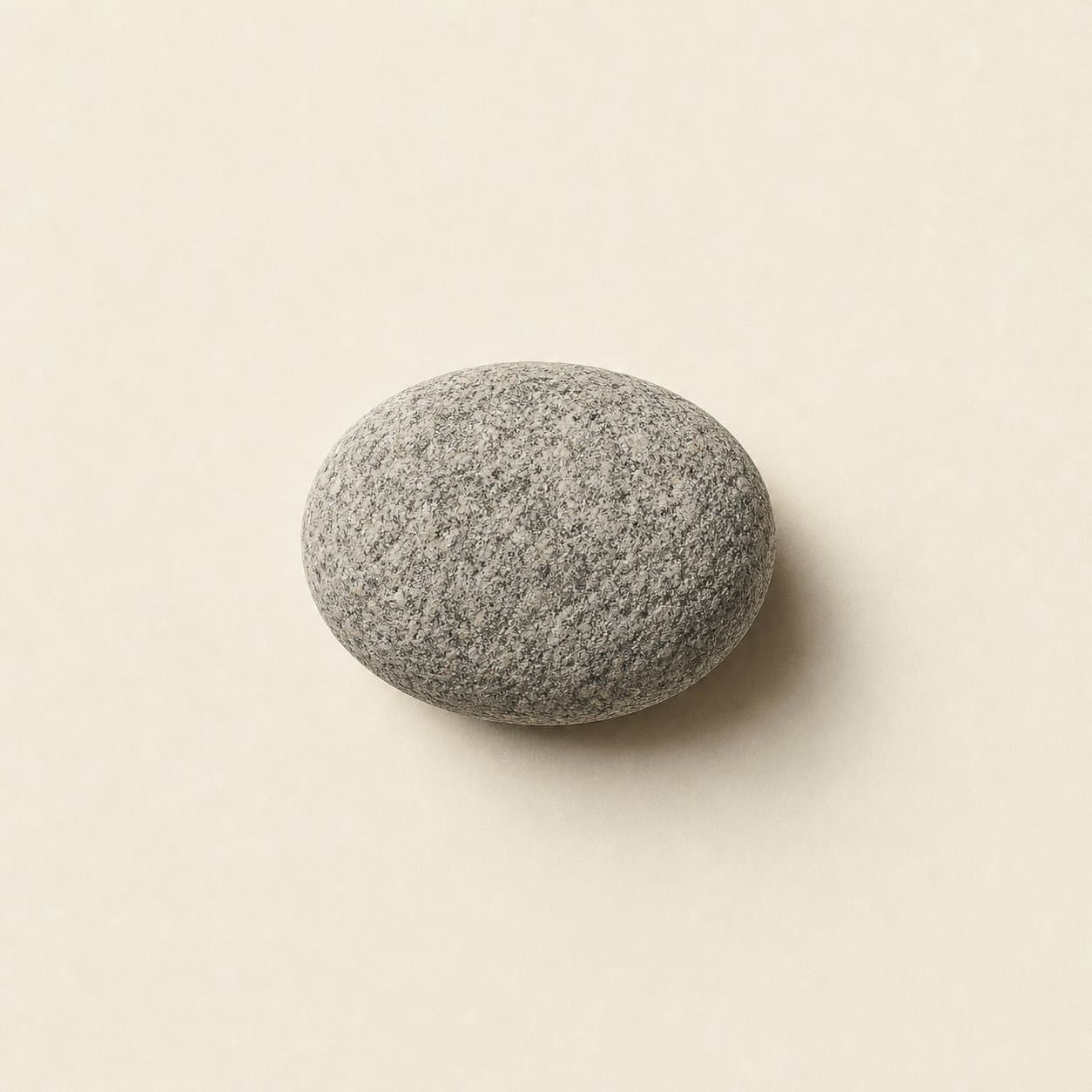 One weathered stone specimen, centred on cream paper