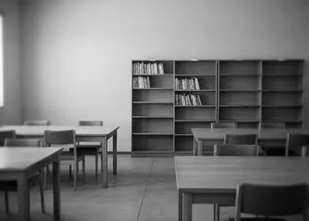 A classroom with wooden desks and shelving, from the master set
